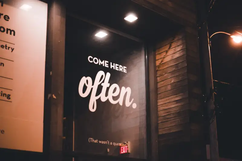 illuminated-window-decal-storefront-nightwebp » Sparks Signs and Graphics Illuminated window decal on a storefront at night drawing customer attention