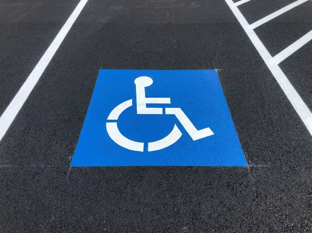 ADA-compliant handicap accessible parking stencil painted in blue and white on fresh asphalt, by Spark Signs in Robinson Township PA
