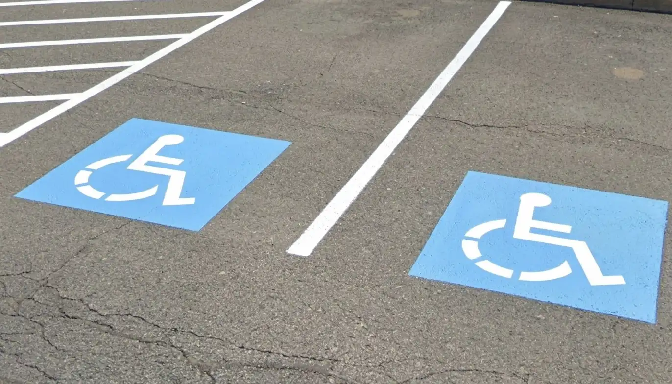 ADA-compliant handicap wheelchair stencils painted on asphalt parking lot, installed by Spark Signs in Warrendale PA