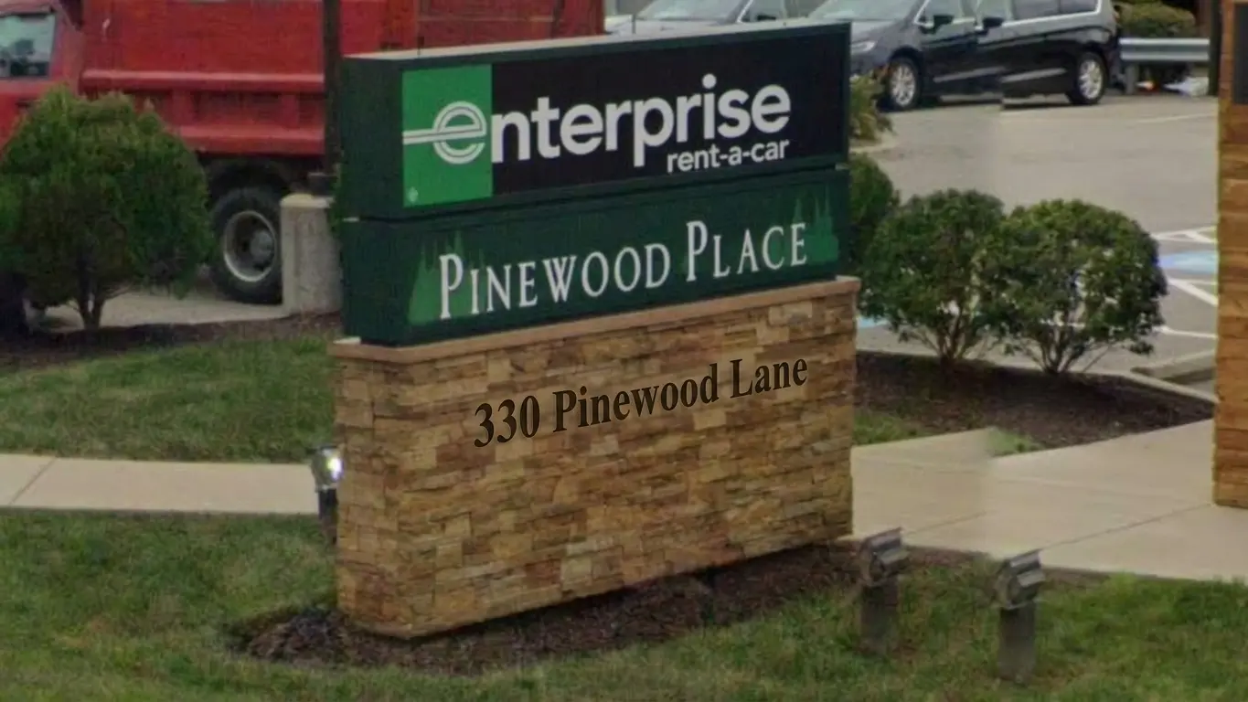Multi-tenant monument sign on a stone base for Pinewood Place featuring an Enterprise Rent-a-Car illuminated cabinet, at 330 Pinewood Lane, installed by Spark Signs in Warrendale PA