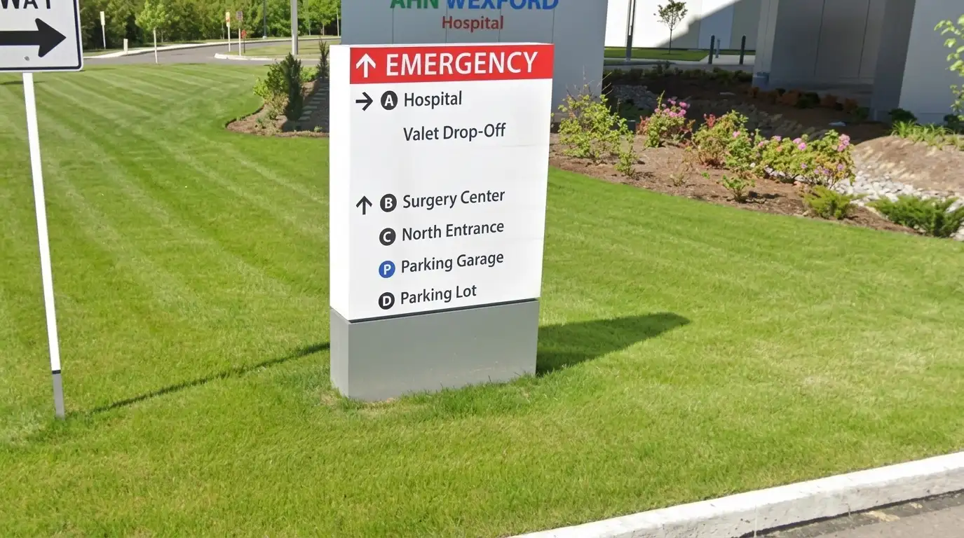 Outdoor multi-panel wayfinding pylon sign with directional arrows for hospital departments including Emergency, Surgery Center, and Parking, installed by Spark Signs in Wexford PA